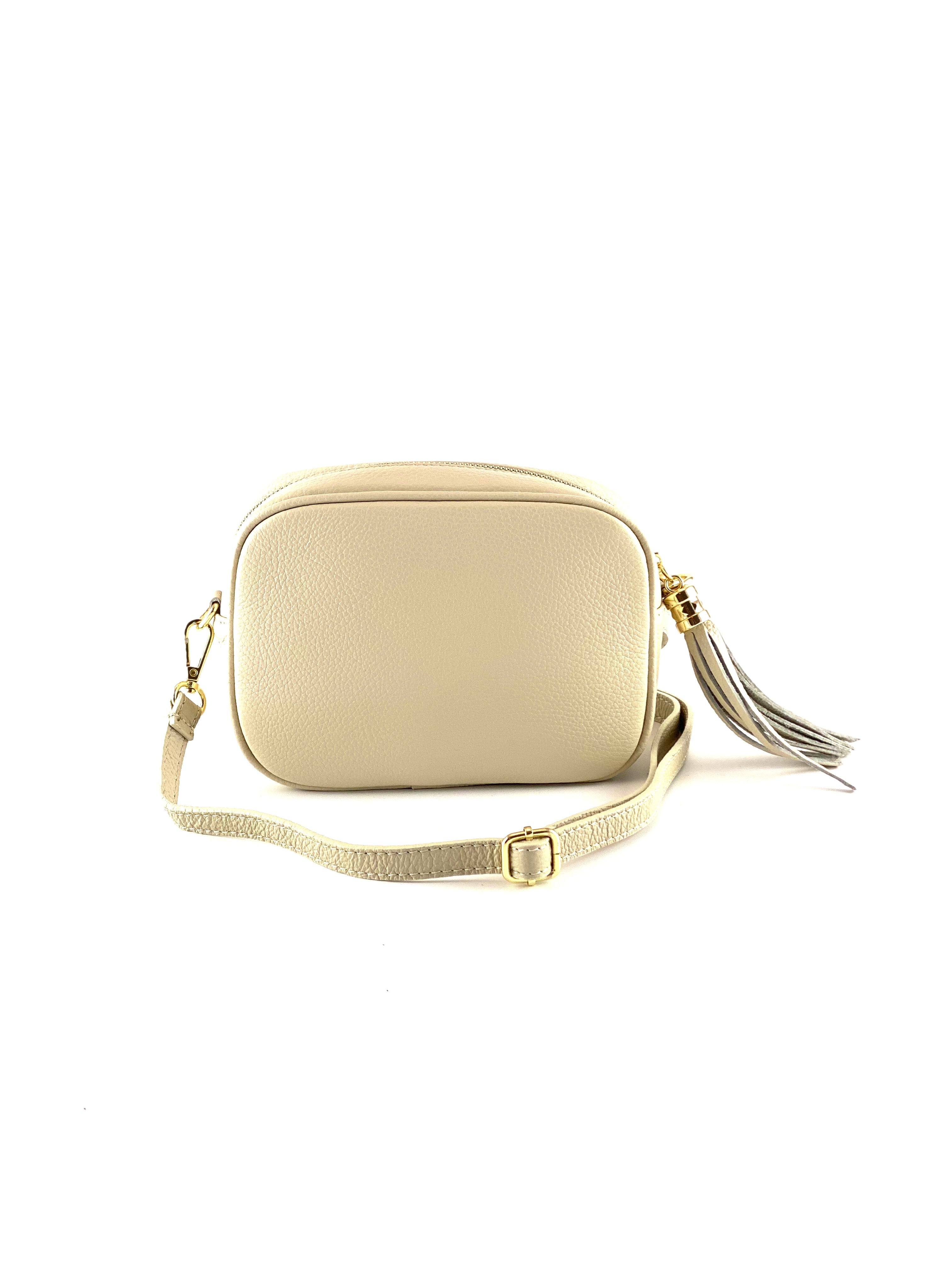 An image of a small cream leather messenger bag with a leather tassel on the zip which opens across the top of the bag.